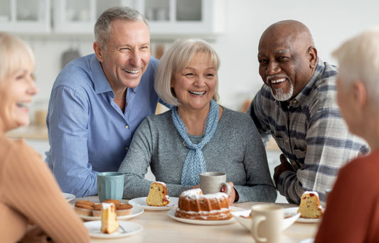 A small group of older adults enjoying a casual cofee together, smiling and relaxed, symbolising emotional wellbeing for seniors through connection and shared fun.
