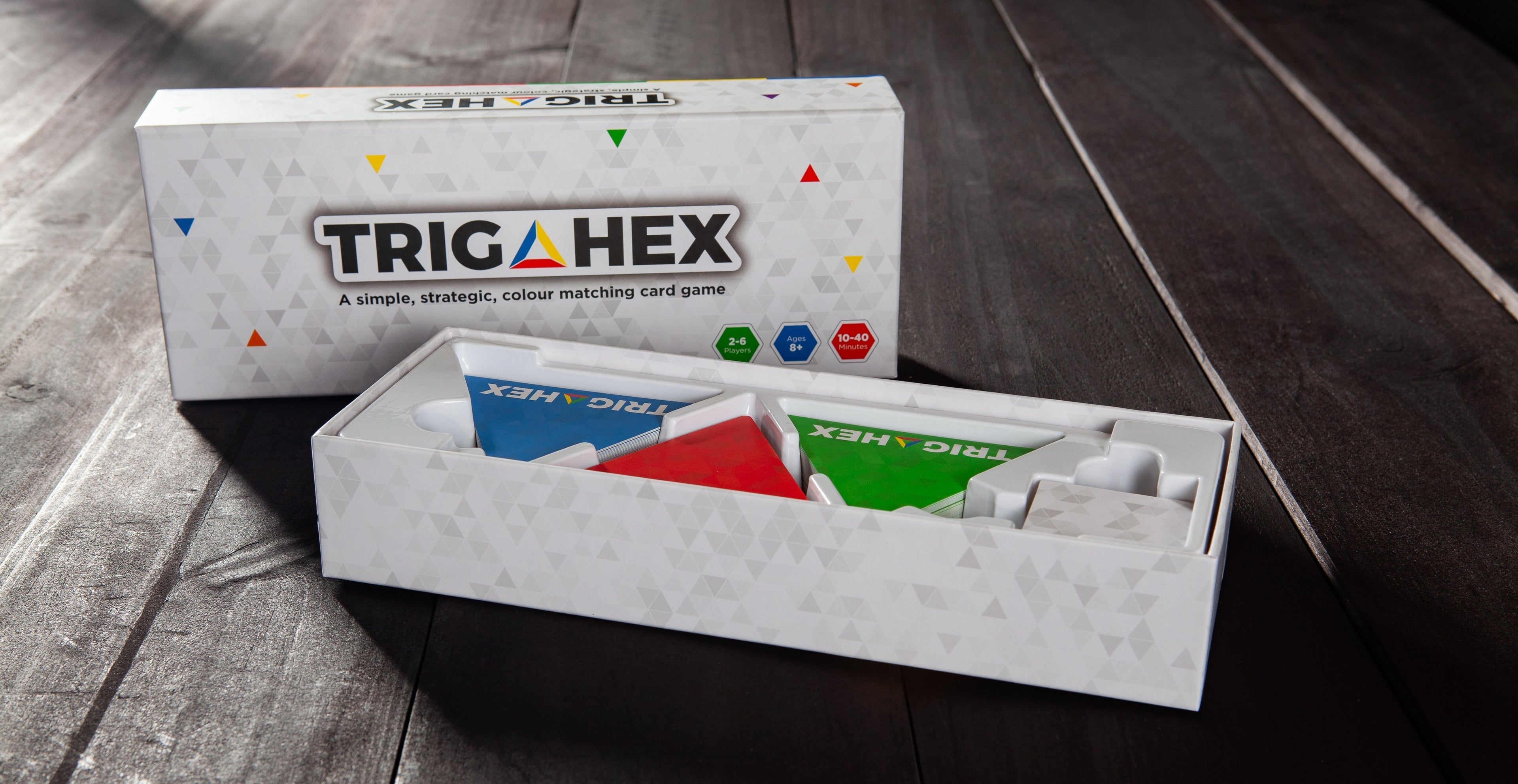 An open Trigahex game box displaying colorful hexagon cards perfect for family-friendly gameplay for all ages