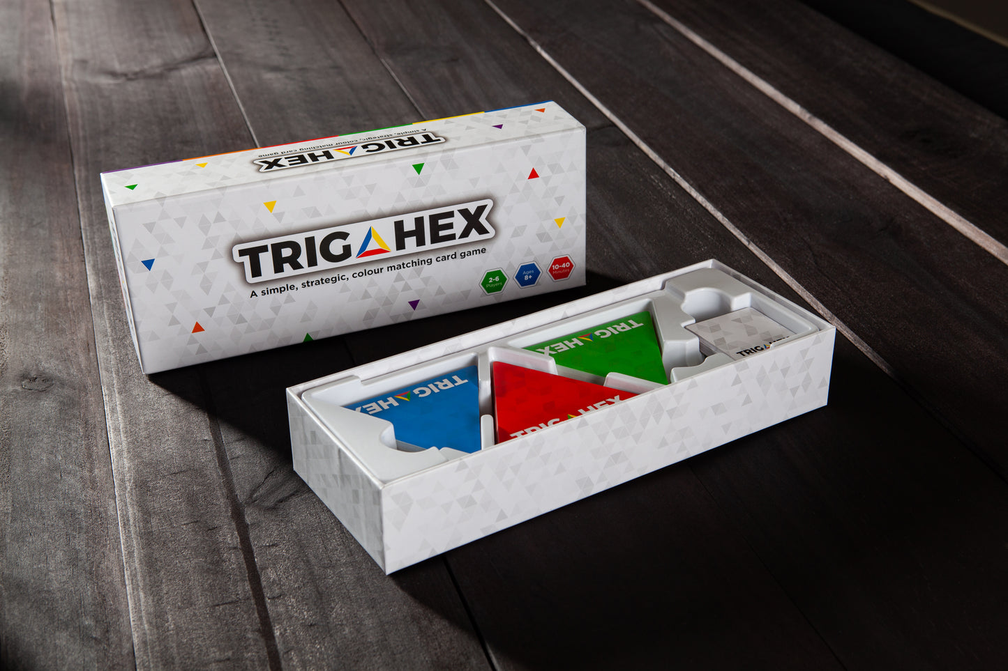Open Trigahex game box displaying colorful cards for a family-friendly, strategy card game.