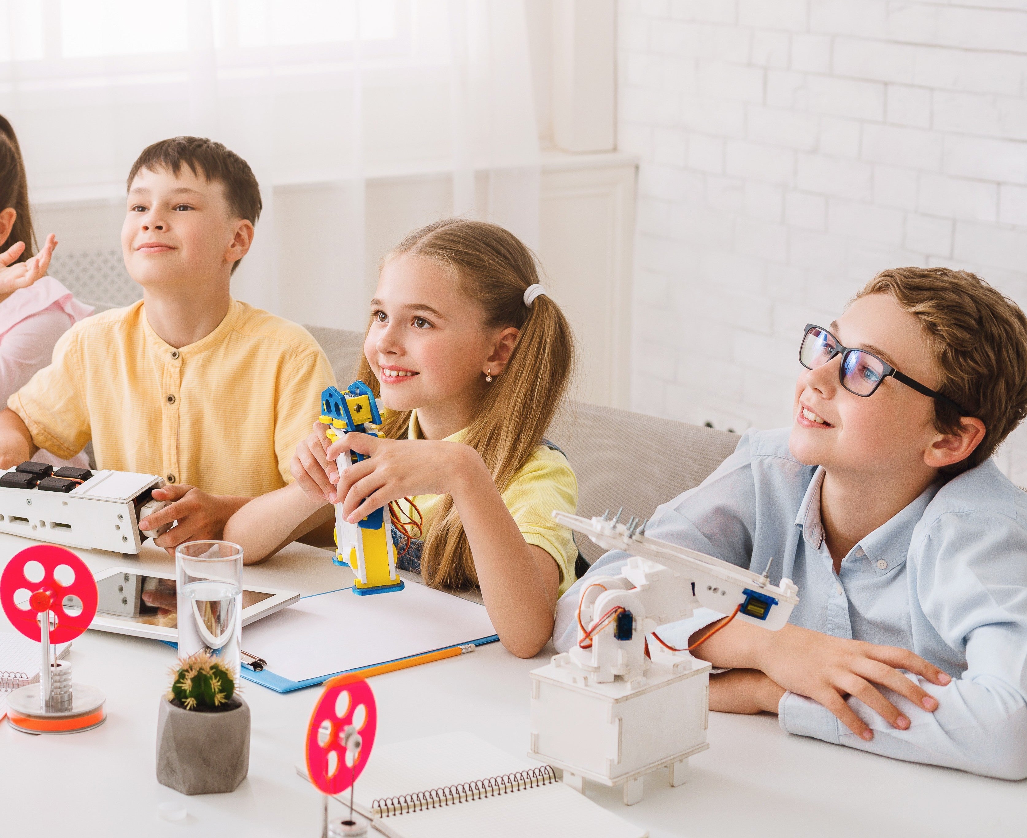 Children engaged in a robotics project with toys on a table.
