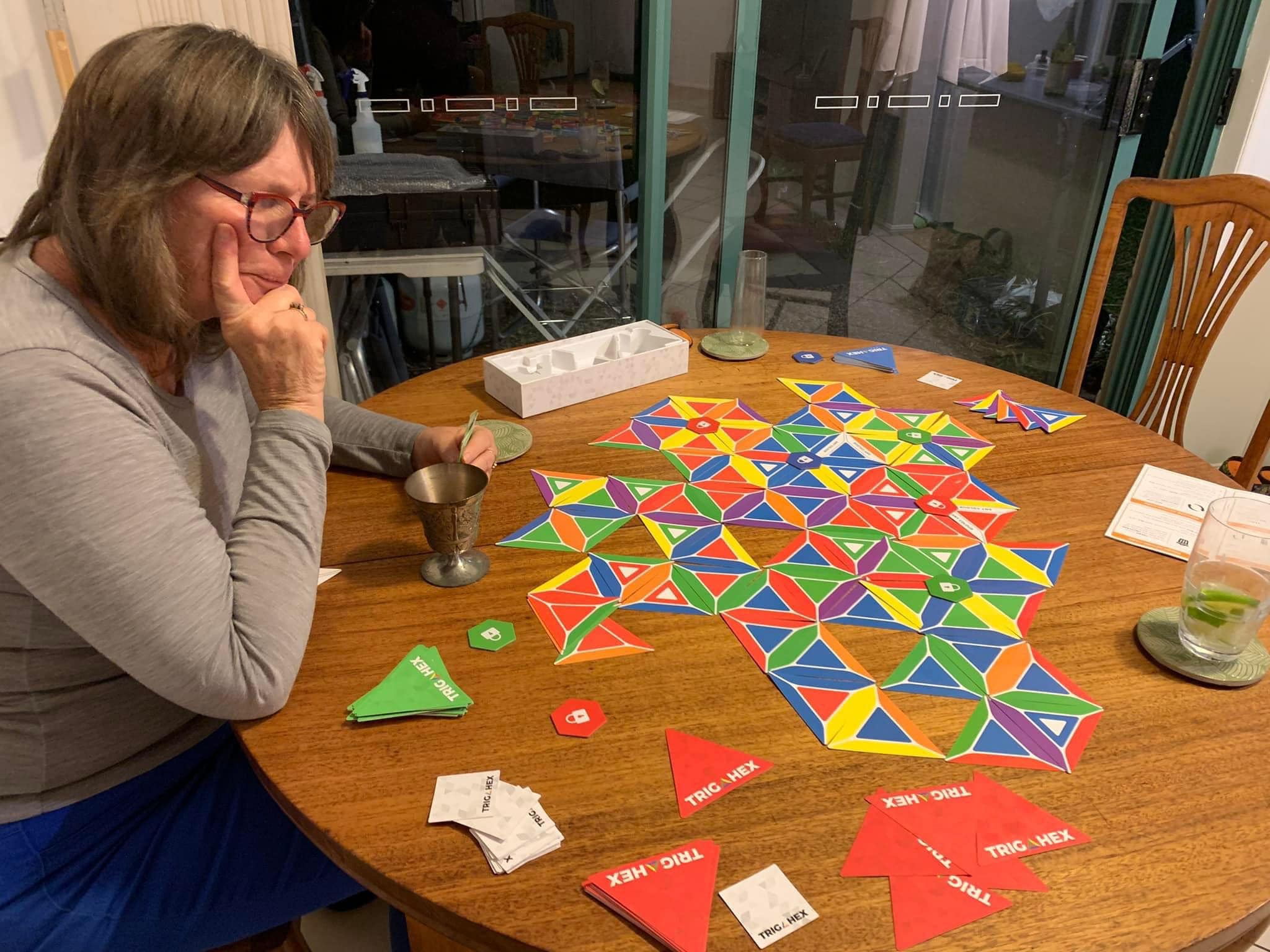 An older player enjoying a strategic game of Trigahex, a fun and easy-to-learn card game that helps keep the mind sharp.